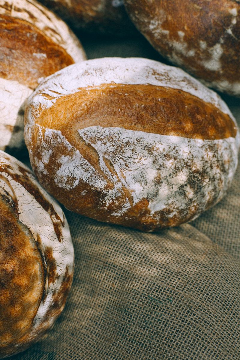 Flour-dusted sourdough loaves on a piece of hessian.