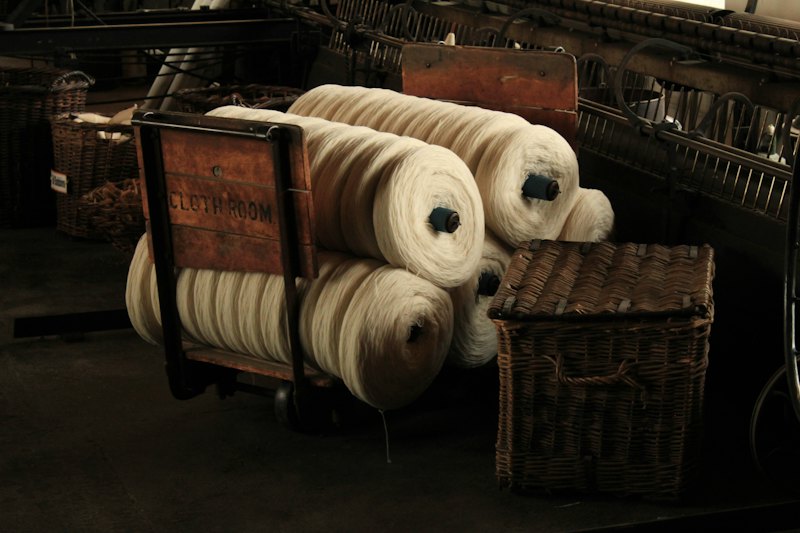 Rolls of undyed wool on a spinning machine.
