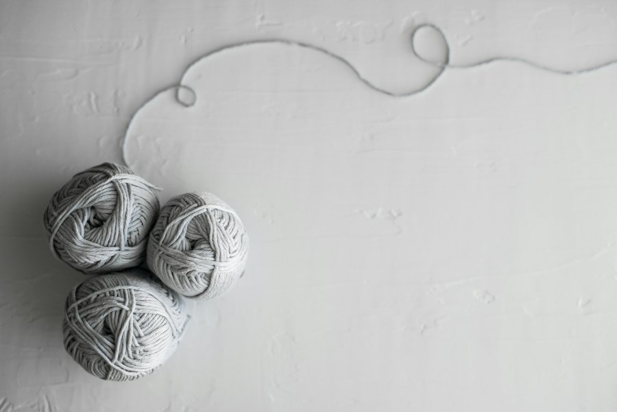 Grey yarn unwinding across a pale surface.