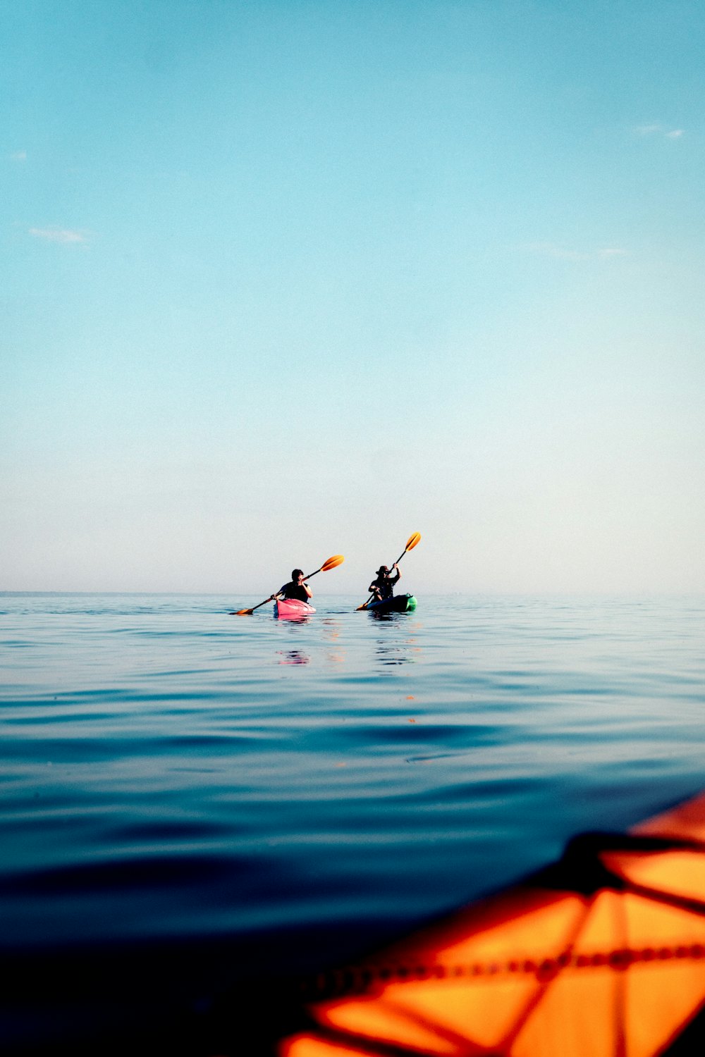 Calm, clear sea with the bow of a kayak at the bottom of the frame.